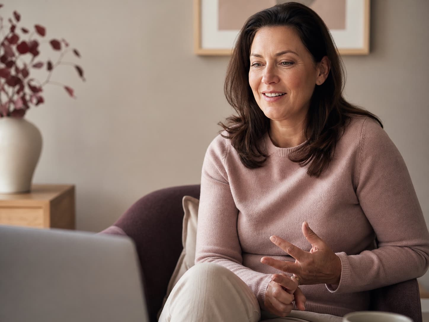 A midlife woman speaking comfortably during a private virtual health visit