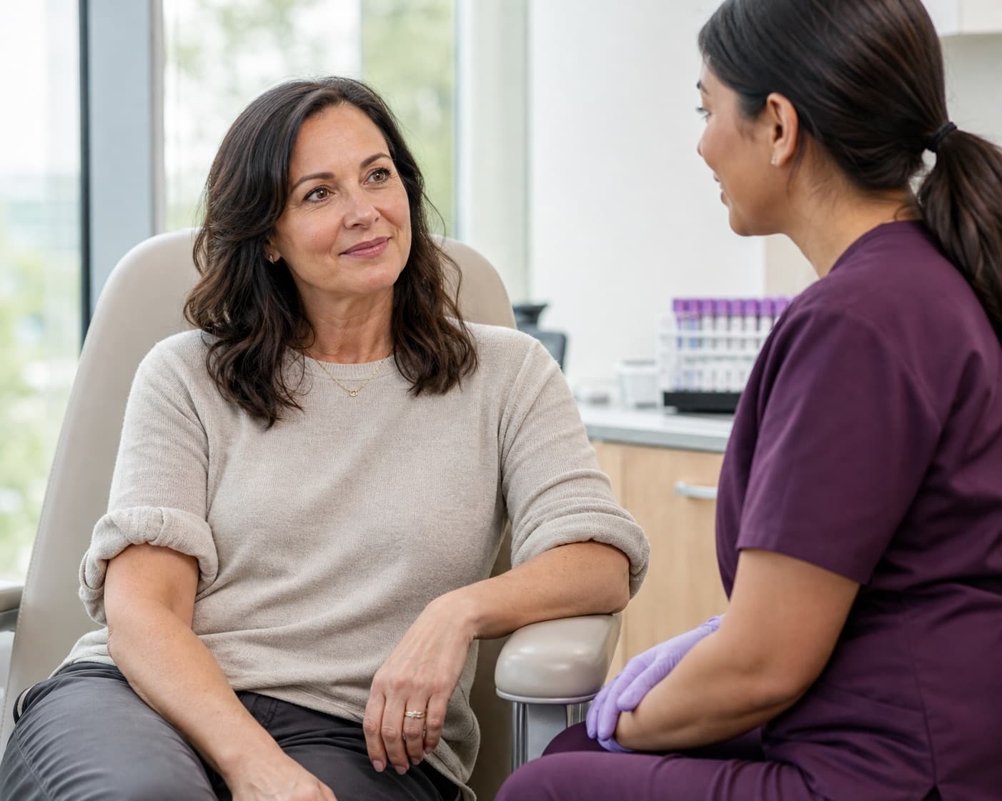 A woman speaking with a phlebotomist before a routine lab visit