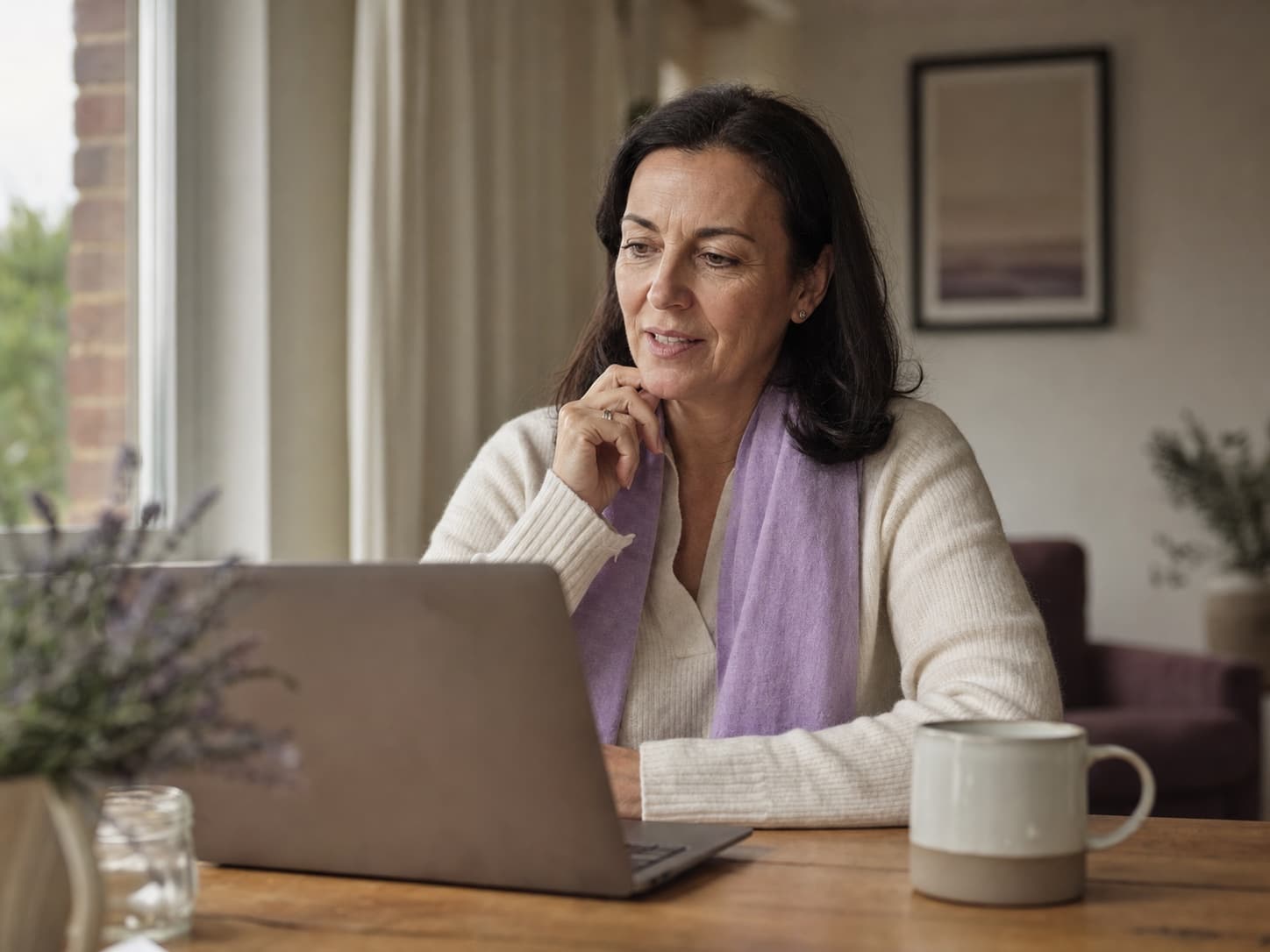 A midlife woman having a thoughtful virtual healthcare visit at home